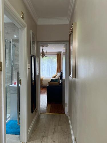 a hallway leading to a living room with a couch at JAN'S HAVEN Wembley Park - lovely 1 bedroom flat, sleeps 4, free parking, 10 minutes from Wembley stadium and Wembley Park station in London