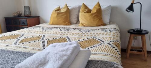 a bedroom with a bed with yellow pillows at Pine Tree Apartment in Porto