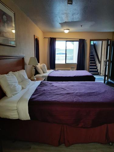 Habitación de hotel con 2 camas con sábanas moradas en Centralia Inn, en Centralia