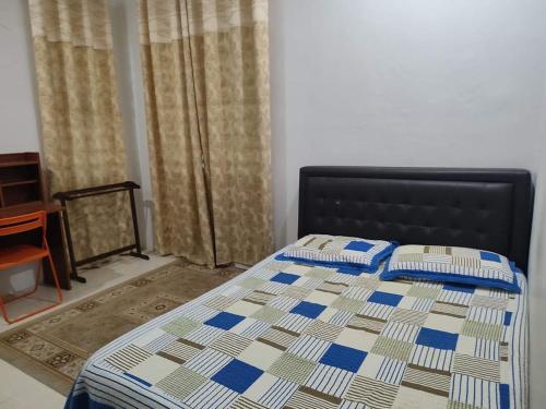 a bedroom with a bed with a quilt on it at Big Banglo Homestay in Bedung