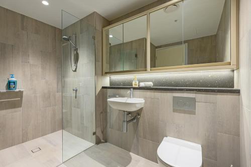 y baño con aseo, lavabo y ducha. en Brand new 2BD Modern Apt near MQ shopping centre en Sídney