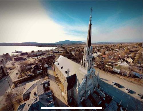 an aerial view of a church with a tall steeple at Cap Magog! Près du lac Memphrémagog et Mont Orford in Magog-Orford
