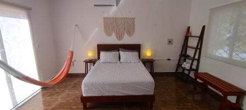 um quarto com uma cama com 2 candeeiros e uma escada em Casa Mahe, Chelem, Yucatán em Chelem