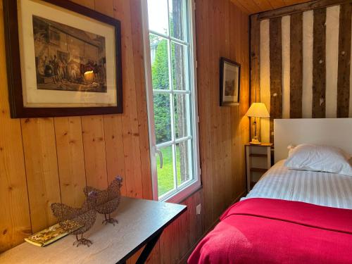 a bedroom with two chickens on a table next to a bed at La Maison de l'Etang in Manerbe