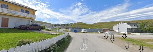 a street with a car parked on the side of a house at Topview in Hammerfest