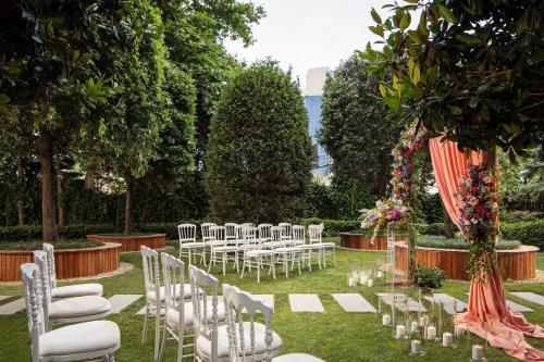 a row of white chairs and tables in a garden at Sheraton Istanbul Levent in Istanbul