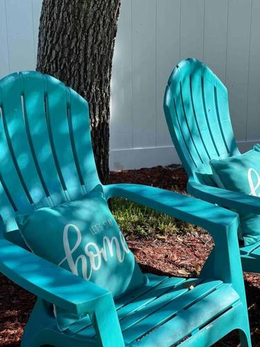 two blue chairs sitting next to a tree at 2 mins to Downtown Atlantic Ave-3 mins to Beach-600mbps-BBQ-Fenced Yard in Delray Beach