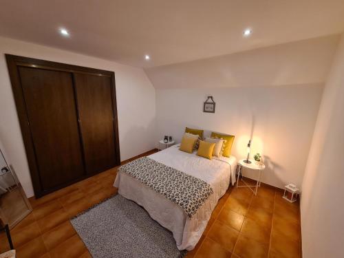 a bedroom with a bed with yellow pillows and a table at O beiral das andorinhas in Moura