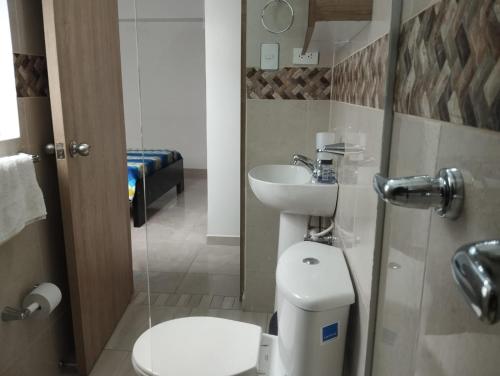 a small bathroom with a toilet and a sink at Habitación doble con baño privado in Sabaneta