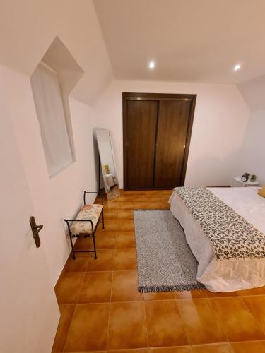 a bedroom with a bed and a chair at O beiral das andorinhas in Moura