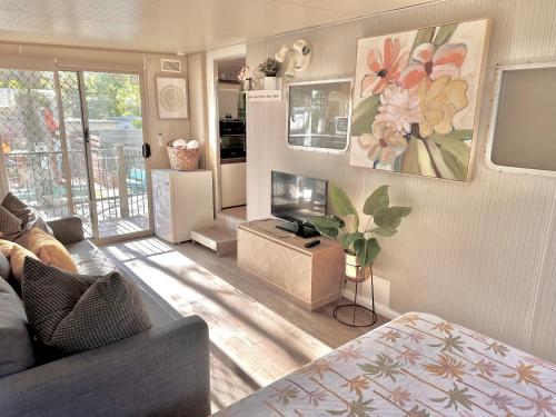 a living room with a couch and a tv at Mornington Peninsula Retro Caravans in Rye