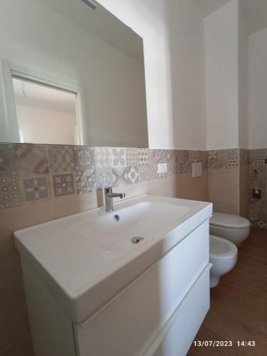 a white bathroom with a sink and a toilet at Holiday Home Ischia in Ischia