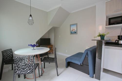 a kitchen and dining room with a table and chairs at Estúdio com Ar Refrigerado a 300 m Praia in Cabo Frio