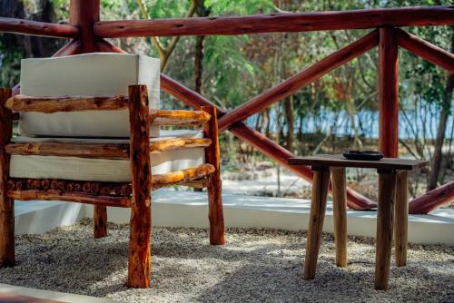 a wooden chair sitting on a porch with a table at Salida Beach in Kizimkazi