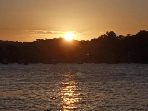 a sunset over a body of water with trees at Recanto do paraiso in Itacaré