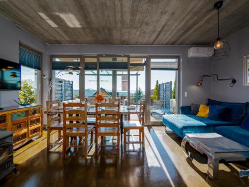 a living room with a blue couch and a table and chairs at Słoneczny Chełm - Dla aktywnych i wypoczywających - Sauna, Balia&Jacuzzi Prive in Myślenice