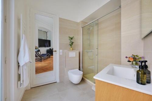 ein Bad mit einem Waschbecken, einer Dusche und einem WC in der Unterkunft Eiffel Tower 5 bedrooms 10 guests with 2 Carpark in Paris