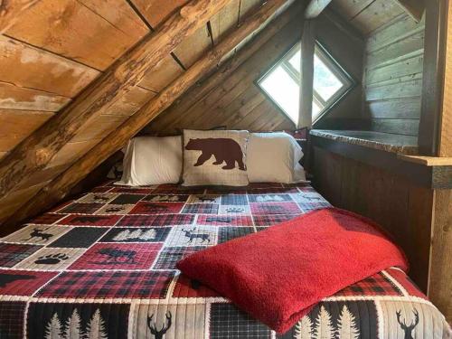 Little Cabin in the Woods. في بوست فولز: غرفة نوم مع سرير دب في العلية