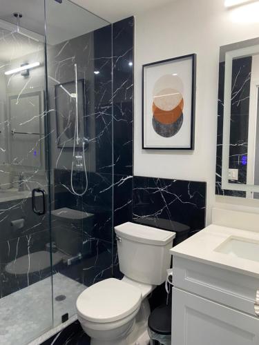 a bathroom with a toilet and a glass shower at Luxury Condo with city skyline views - Mins to YYZ in Toronto