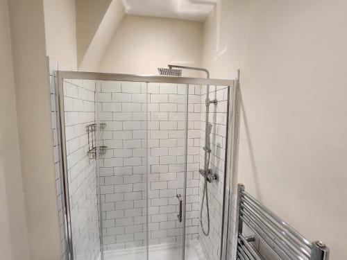 een douchecabine in een badkamer met witte tegels bij Leopold House Liverpool in Liverpool