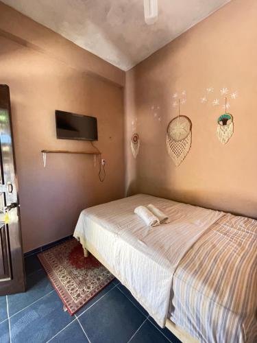 a bedroom with a bed and a tv on the wall at Casa Lol-cab Hostal in Valladolid