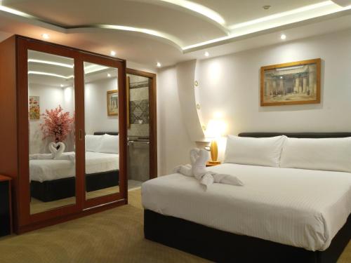 ein Hotelzimmer mit 2 Betten und einem Spiegel in der Unterkunft باب المدائن in Kairo