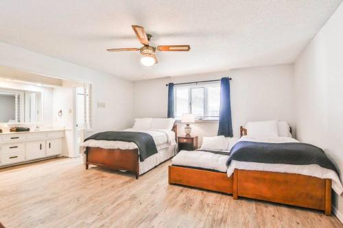 a bedroom with two beds and a ceiling fan at Hot Tub, Privacy, sleeps 10 & TONS of Space! in Lubbock