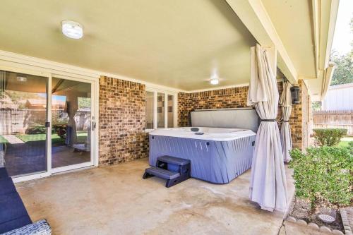 um quarto com uma banheira e um pátio em Hot Tub, Privacy, sleeps 10 & TONS of Space! em Lubbock