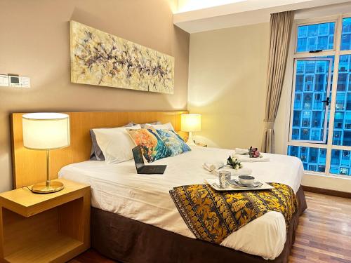 een slaapkamer met een bed met een tafel en een lamp bij Heart of Kuala Lumpur, walking distance to KLCC, pubs and Michelin Restaurants in Kuala Lumpur