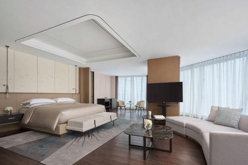 een slaapkamer met een bed en een woonkamer bij Yancheng Marriott Hotel in Yancheng