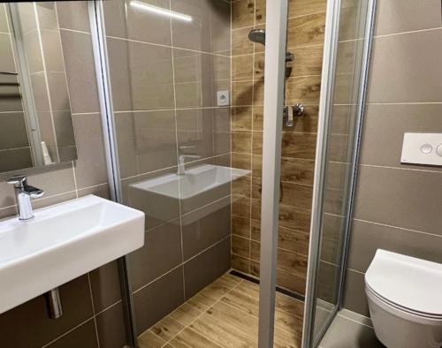uma casa de banho com um chuveiro, um lavatório e um WC. em Sunset Apartman Novi Vinodolski em Novi Vinodolski