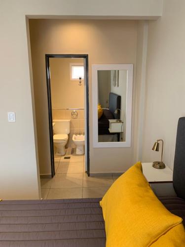 Habitación con baño con manta amarilla en la cama en Amaru - Amplio departamento céntrico con cochera en Corrientes