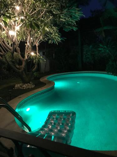 una piscina por la noche con una silla junto a ella en SOL Y SALSA bnb, en Cuernavaca