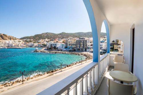 a balcony with a view of the ocean and buildings at P i g a d i a B a y in Karpathos Town