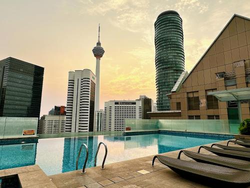 een zwembad bovenop een gebouw met een stad bij Heart of Kuala Lumpur, walking distance to KLCC, pubs and Michelin Restaurants in Kuala Lumpur