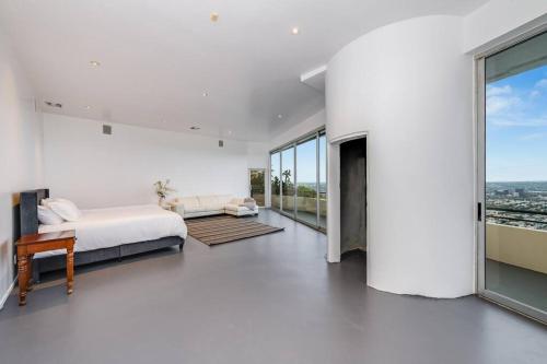 a white bedroom with a bed and a large window at Jetliner 180' City/Ocean Views! Huge sauna/steam! in Los Angeles