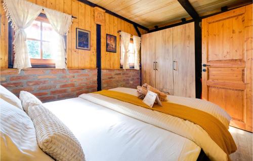 a large bed in a room with wooden walls at 2 Bedroom Gorgeous Home In Gornji Daruvar in Daruvar