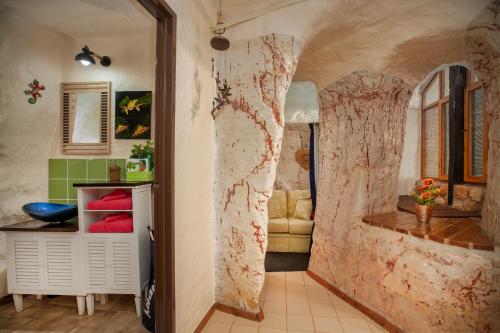 Habitación con una pared cubierta de mármol. en Dinky Di's Dugout en Coober Pedy