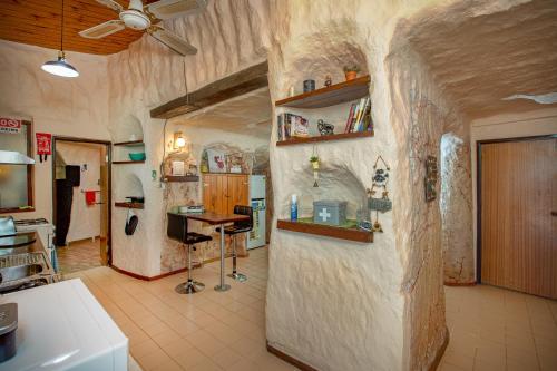 una cucina con una stanza con un muro e un bancone di Dinky Di's Dugout a Coober Pedy