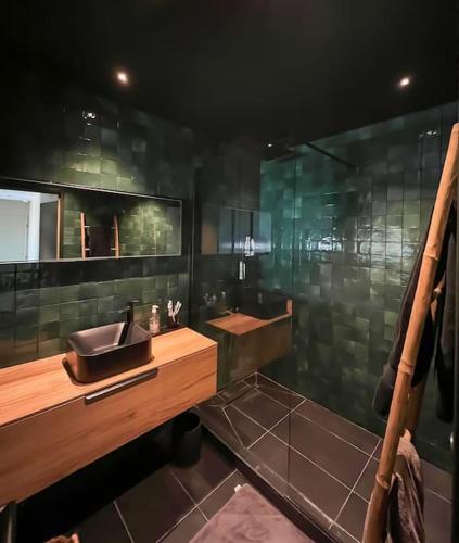 La salle de bains est pourvue d'un lavabo et d'une paroi en verre. dans l'établissement Évasion Chic à Boulogne : Votre Escapade Élégante, à Boulogne-Billancourt