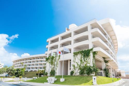 a large white building with ivy on it at EM Wellness Kurashinohakko Lifestyle Resort in Kitanakagusuku