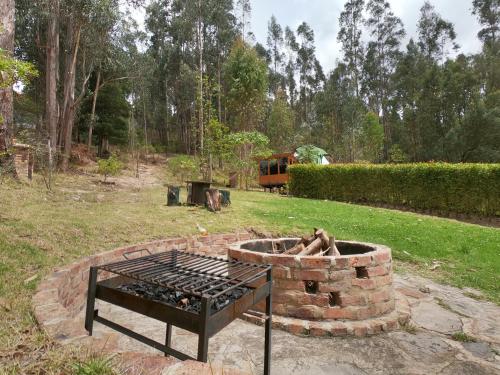 a fire pit in the middle of a yard at Libélula Glamping con jacuzzi in Duitama
