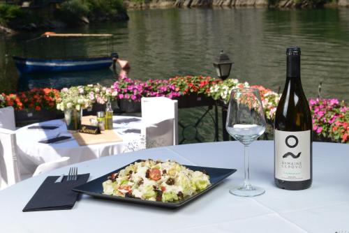 a table with a plate of food and a bottle of wine at Canyon Matka Hotel in Matka