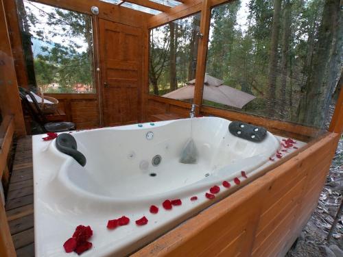 una bañera en una cabaña con rosas. en Libélula Glamping con jacuzzi, en Duitama