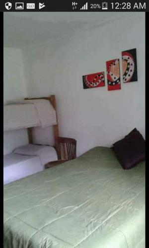 a bedroom with a bed and two pictures on the wall at Complejo Aguas de Reposo CASA DE CAMPO in San Rafael