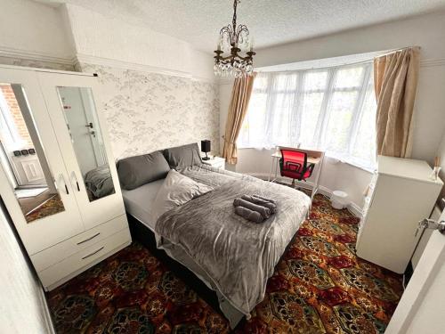 a bedroom with a bed and a chandelier at Stonehouse Cottage Near QE & UOB in Birmingham