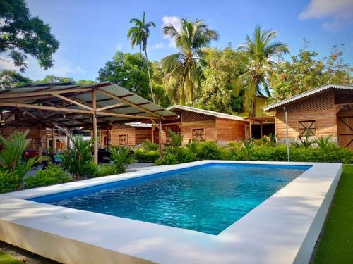 a swimming pool in front of a house at Rustika Logde in Puerto Viejo