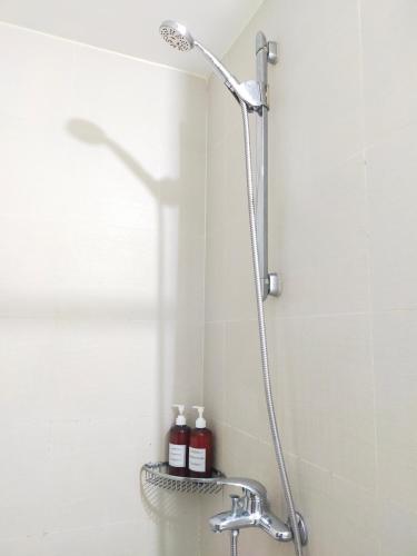 La salle de bains est pourvue d'une douche et de 2 bouteilles de shampoing. dans l'établissement Condo in Azure Urban Resort Residences-Paranaque City, à Manille
