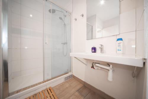 a bathroom with a shower and a sink and a mirror at Enjoy Hostel in Paris