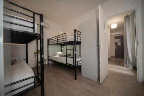 パリにあるエンジョイ ホステルの二段ベッド2台と廊下が備わる客室です。
